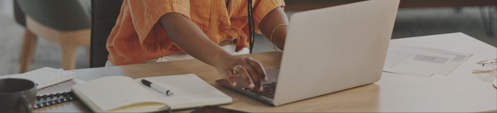 A person typing on a grey laptop